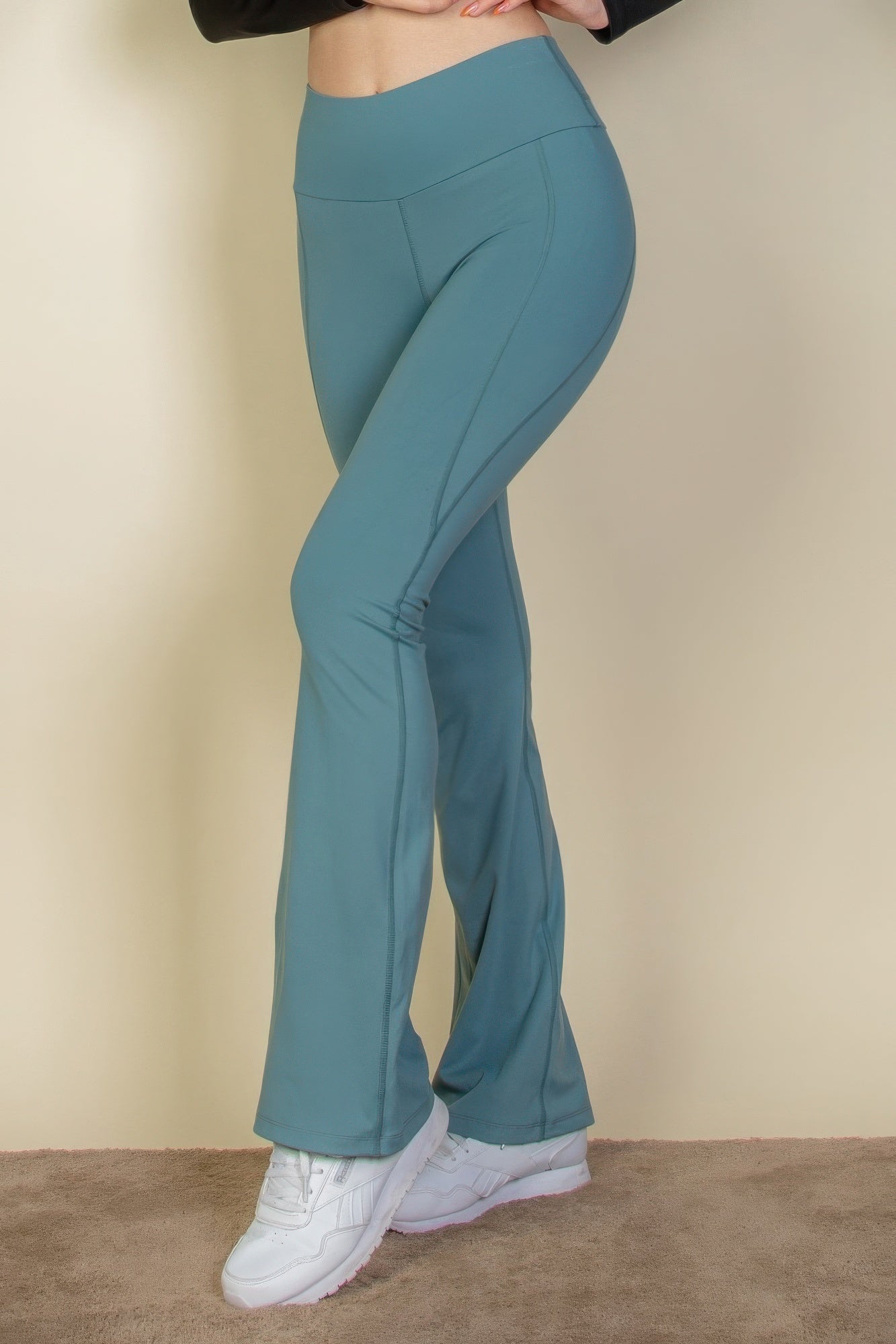 Slate green flared leggings with wide waistband and curved back seam detail
