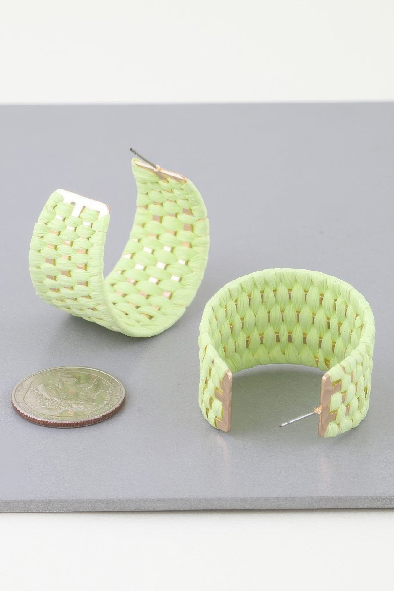 Light green woven wide hoop earrings with textured basket weave and gold-toned posts