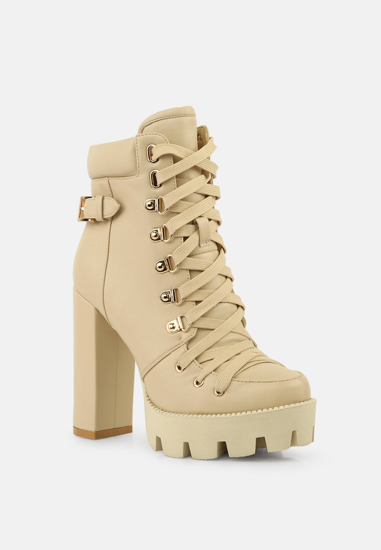 Beige ankle combat boot with lace-up front, metal eyelets, and tall block heel
