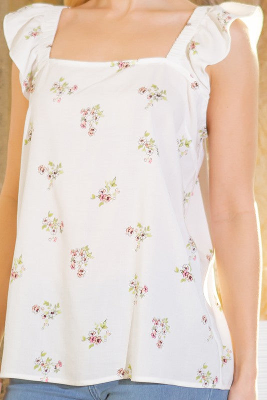 Close-up woven top: ruffled sleeves, square neckline, white with floral print