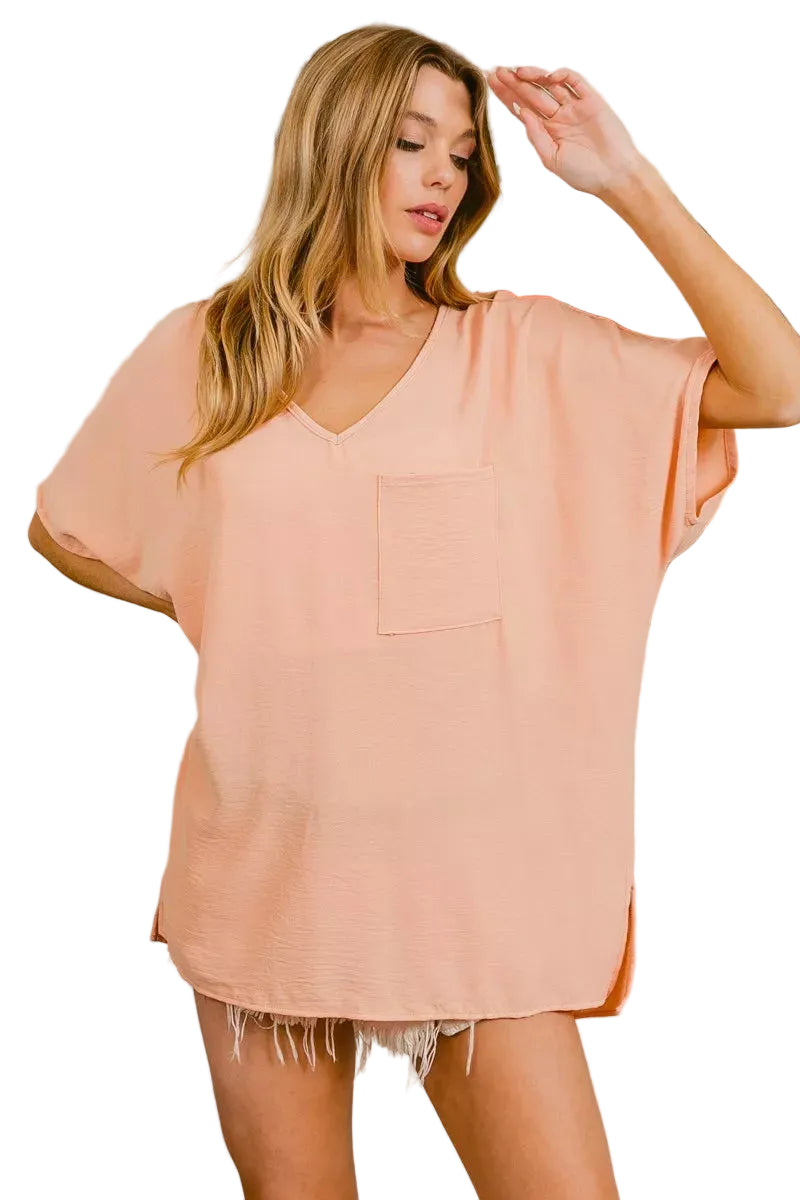 Peach V-neck boxy top with front pocket and relaxed short sleeves