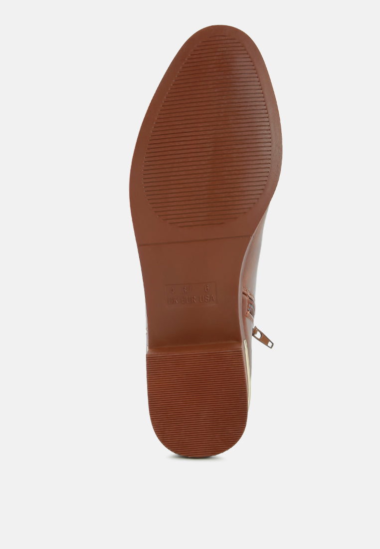 Brown outsole view with textured tread on the bottom of the ankle boot