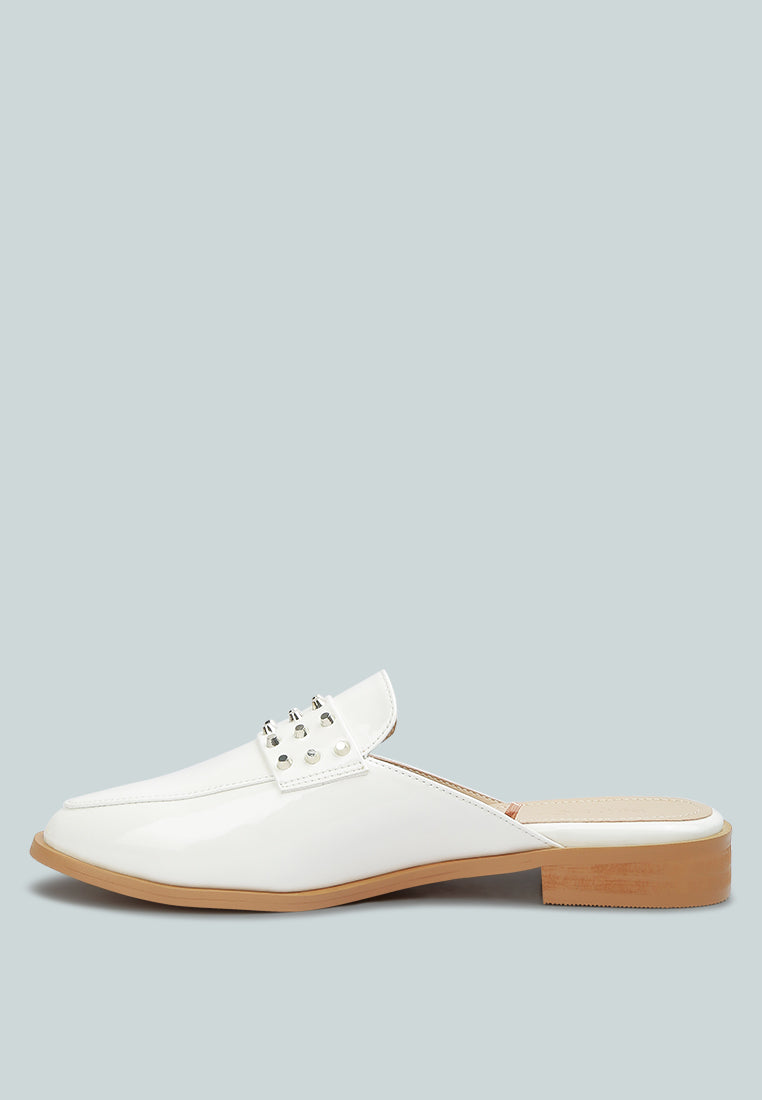 Yashta patent studded flat mules (white) profile view with square toe and flat sole.
