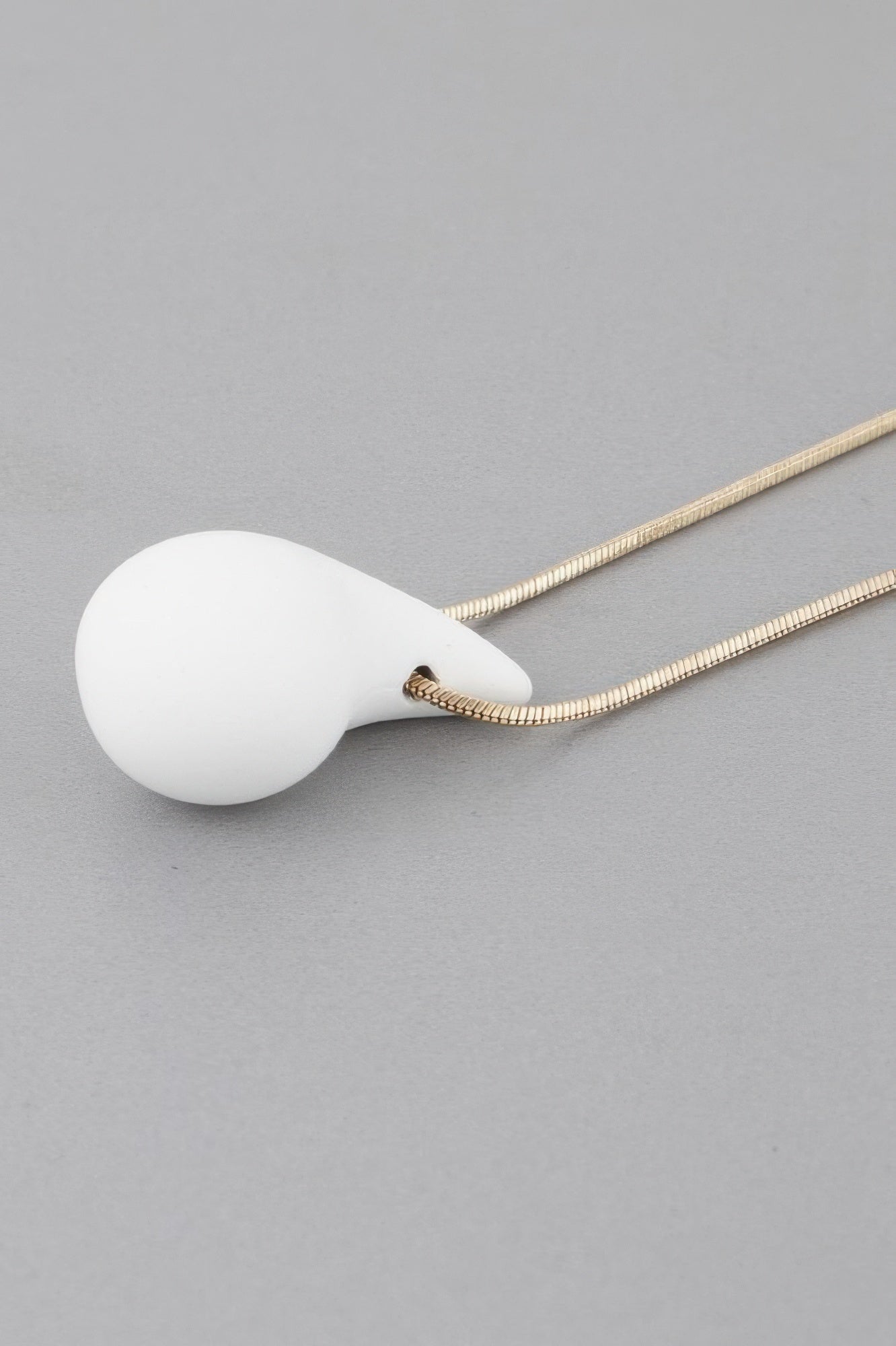 Yin Teardrop Necklace close-up, gold chain with white teardrop pendant
