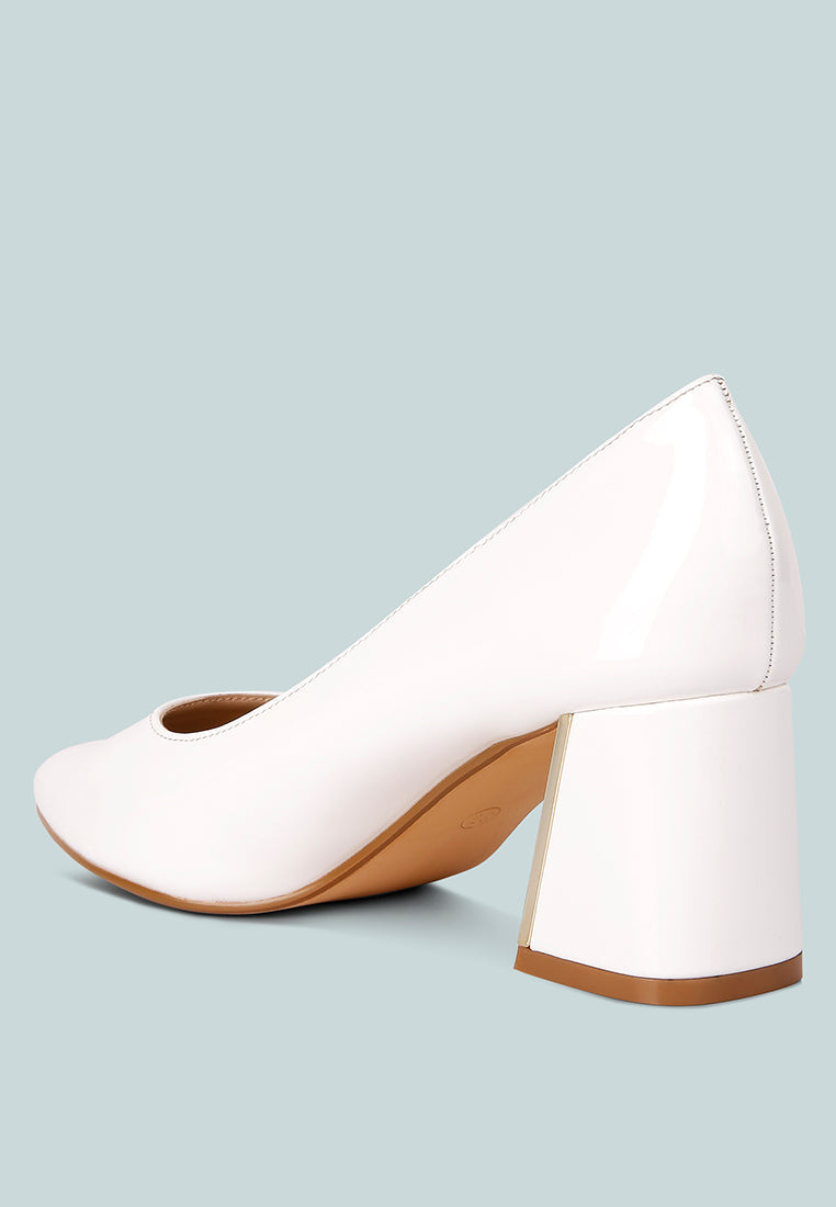 White pump angled view: pointed toe and gold block heel with glossy finish