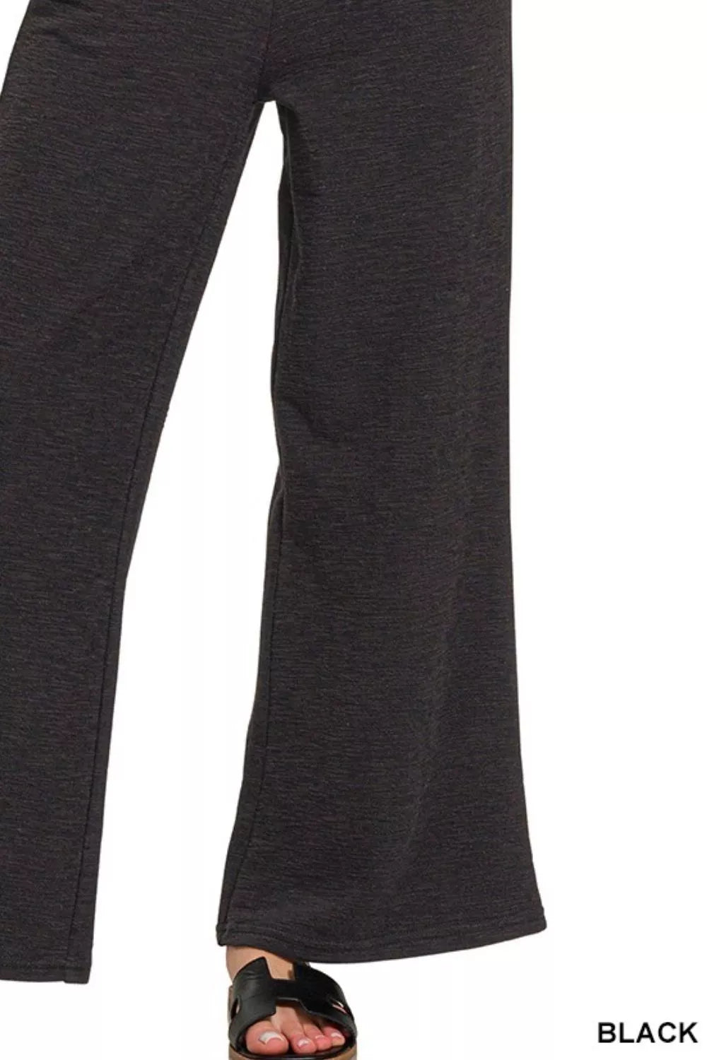 Black wide-leg pants with flared hem and subtle slub cotton texture