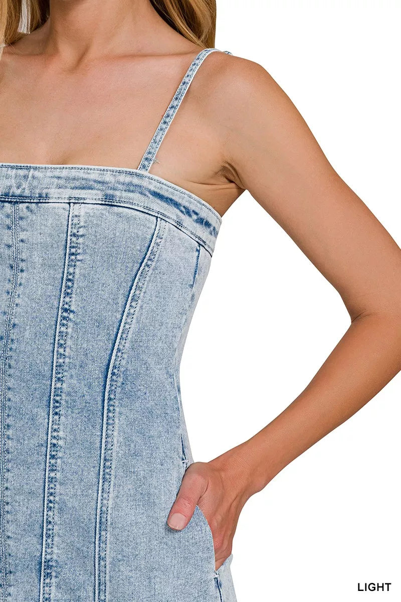 Close-up of light-wash denim dress with exposed vertical seam stitching on front