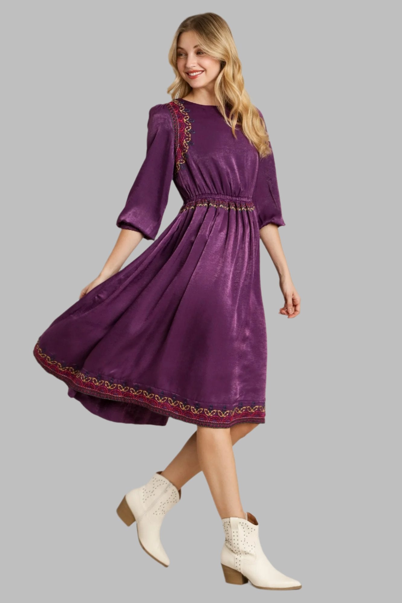 Purple satin midi dress with three-quarter sleeves, gathered skirt, and gold embroidered border
