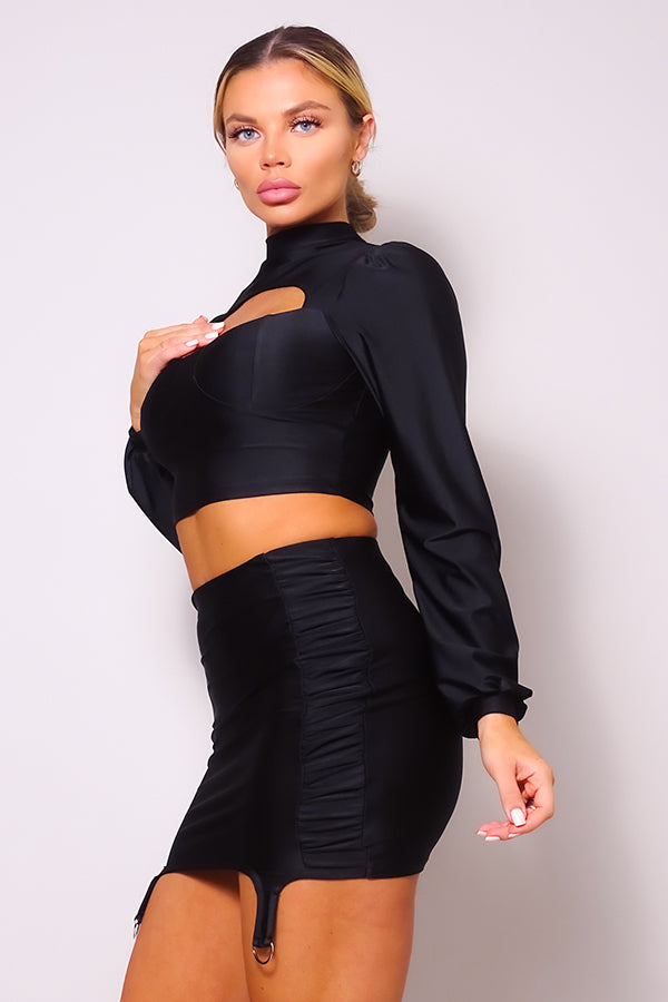 Black cropped turtleneck blouse with front cutout, paired with ruched garter mini skirt