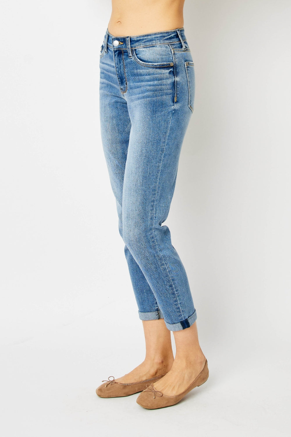 Medium blue slim jeans with cuffed ankle hem, side view, denim seam details