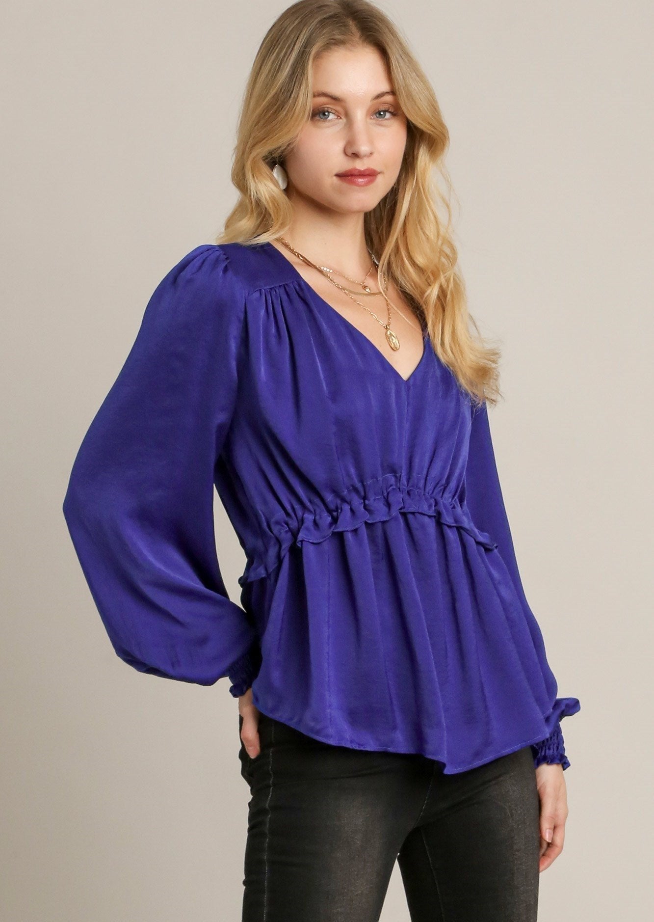 Blue satin baby doll top with V-neck, gathered cuff sleeves, and ruched waist