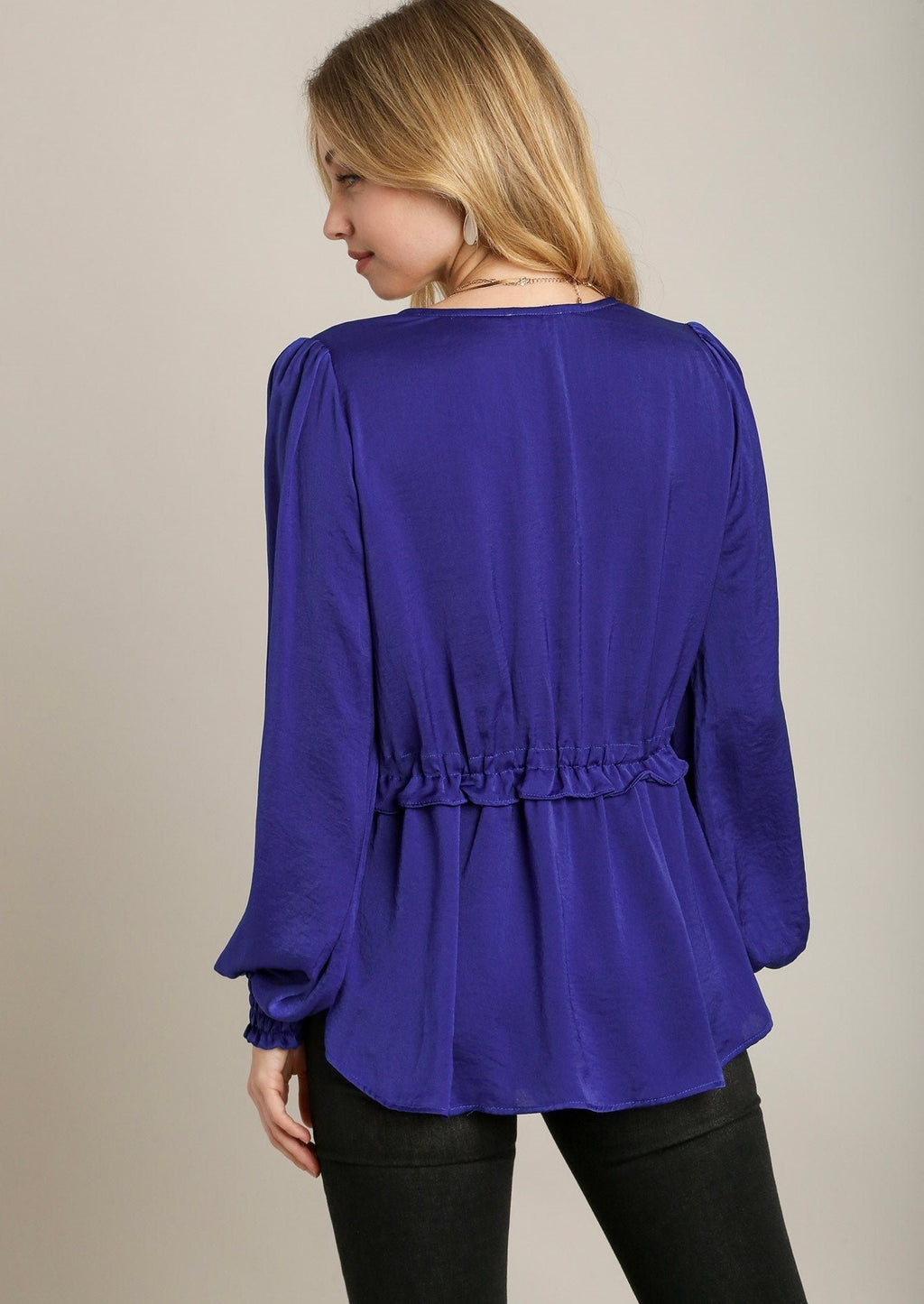 Back view: blue satin baby doll top with gathered long sleeves and peplum hem