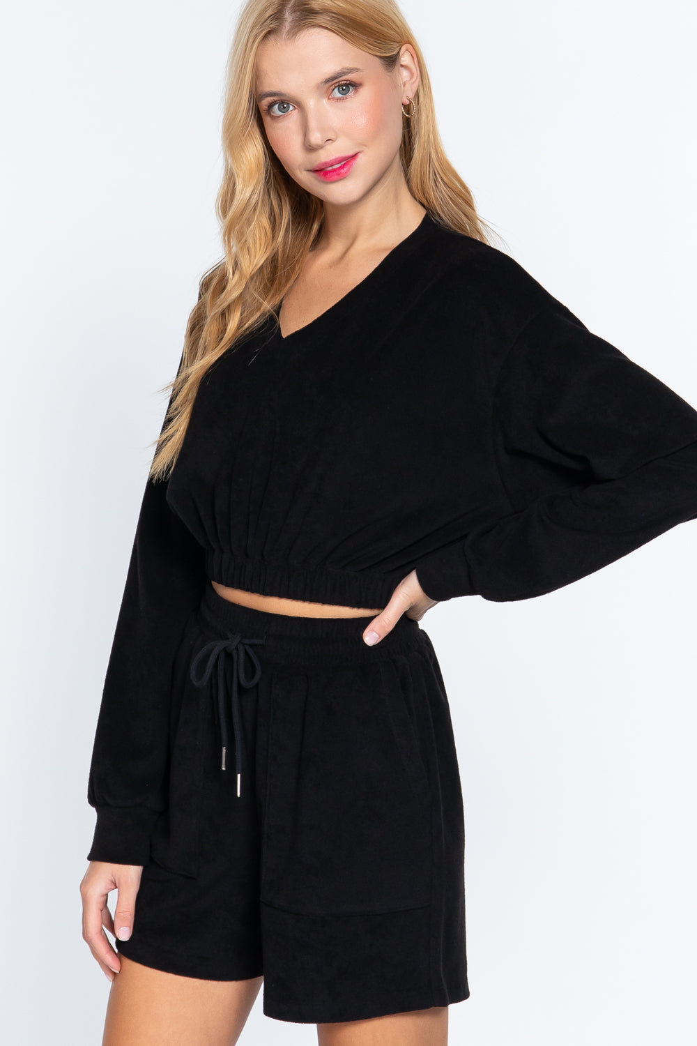 Black terry toweling top with V-neck and elastic waist hem, long sleeves