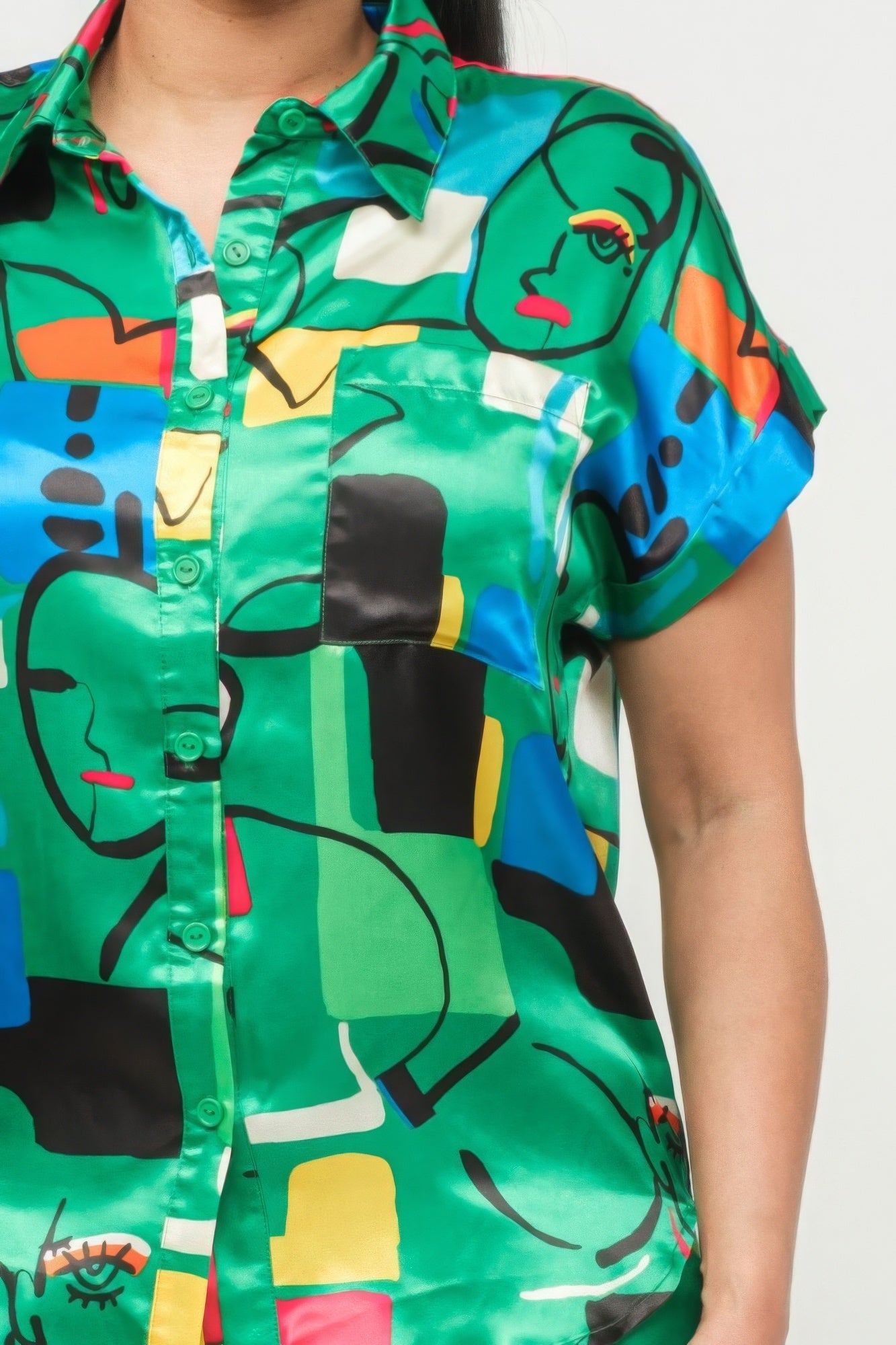 Green satin button-up shirt front with colorful abstract print and button placket