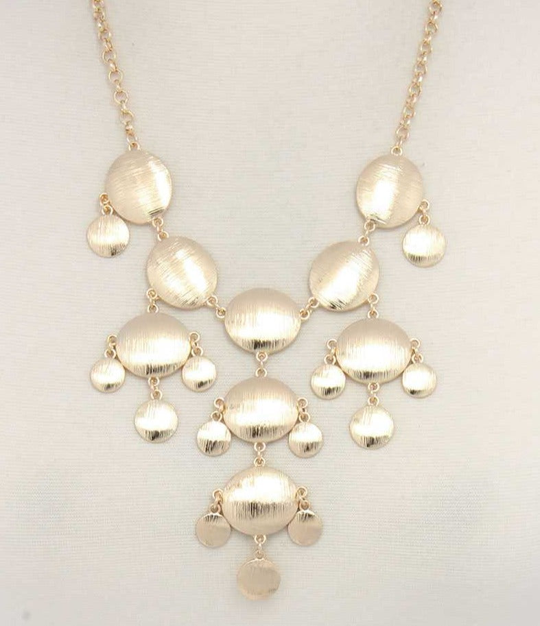 Gold brushed oval dangle metal necklace with coin-like disc charms and tassels