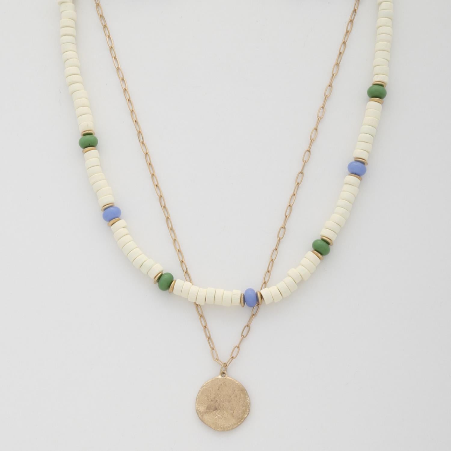 Layered coin bead necklace in ivory with blue/green accents and round gold-toned pendant