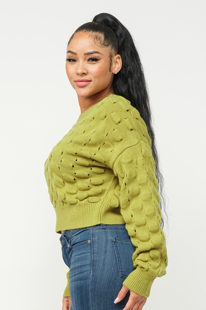 Side view of lime green checker-knit sweater top with chunky raised pattern