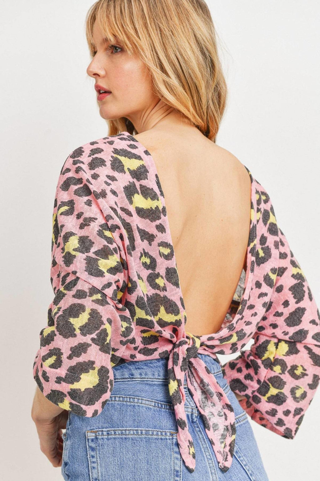 Open-back pink leopard knit top with tied bow detail, three-quarter sleeves