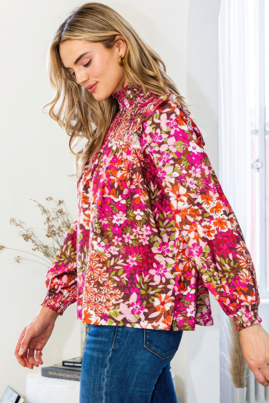 Dark pink floral blouse with mock neck and smocked yoke, side view of sleeves