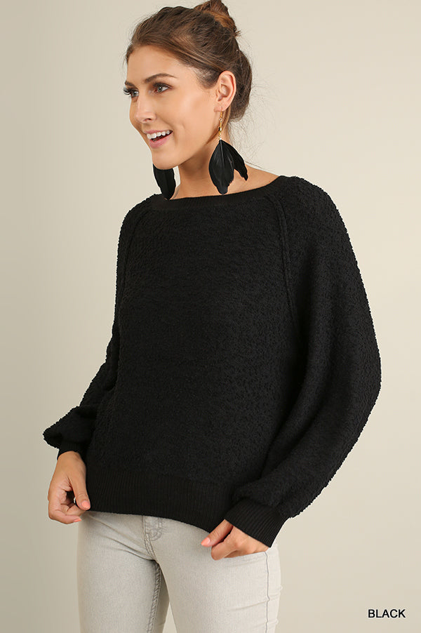 Black puff-sleeve boat-neck sweater, textured knit with wide relaxed sleeves.