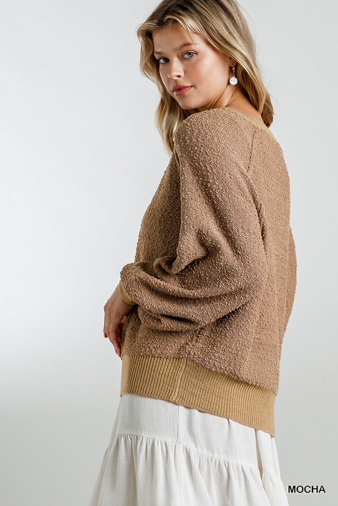 Mocha puff-sleeve boat-neck sweater, side view showing textured knit and wide cuffs.
