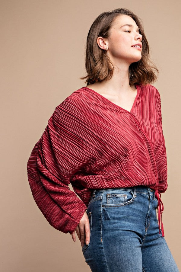 Burgundy satin pleated top with V-neck and drawstring tie at side seam