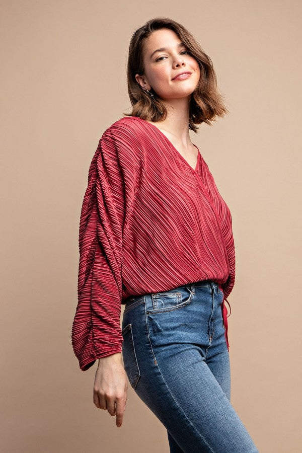 Burgundy satin pleated blouse with long loose sleeves and snap button front