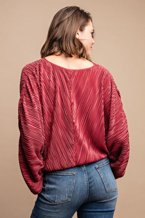 Back of burgundy satin pleated top with long sleeves and drawstring waist tie
