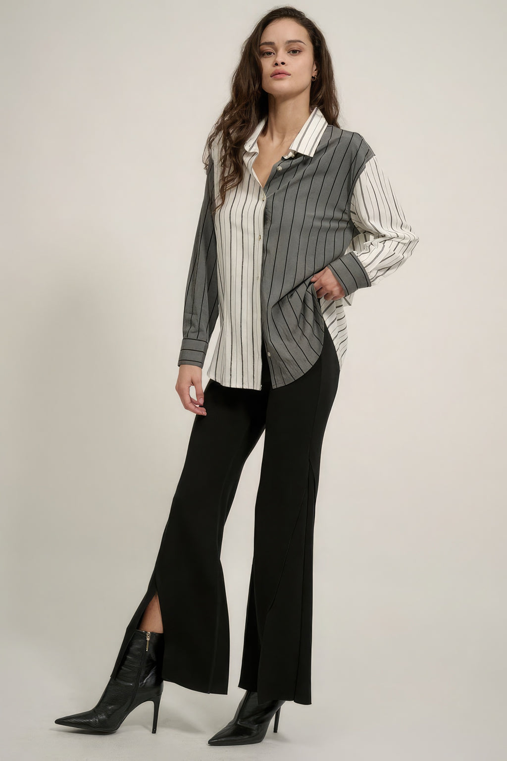 Full-length black flare pants with split hem at knee and exposed seam