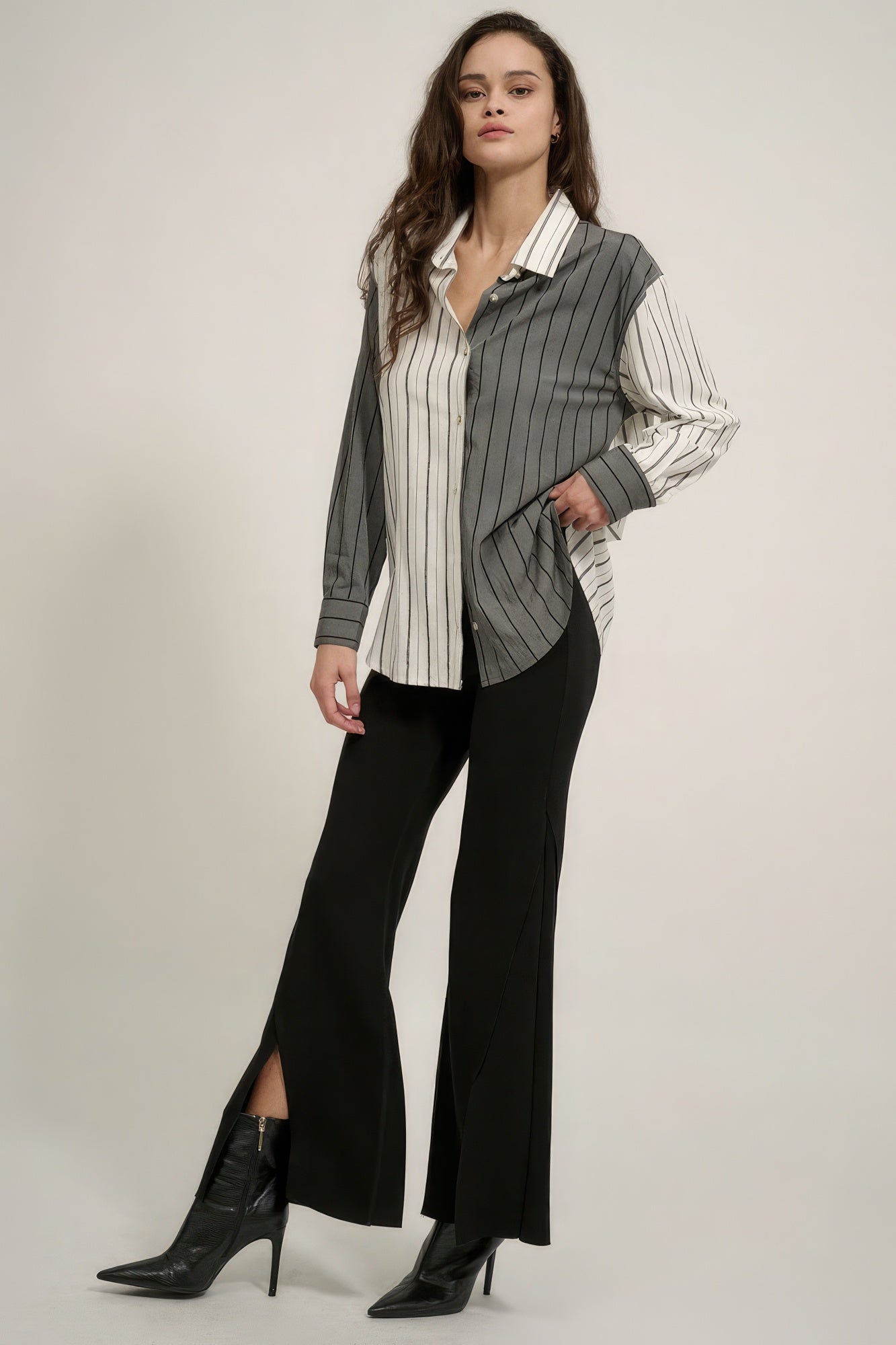 Full-length black flare pants with split hem at knee and exposed seam