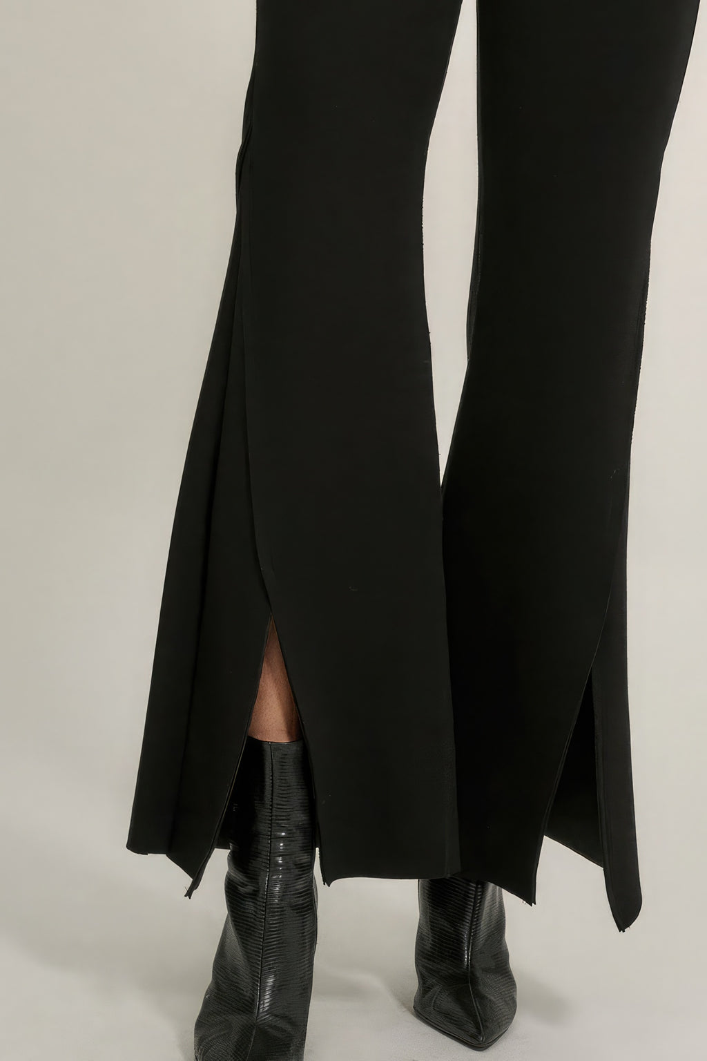 Black bell-bottom pants with long side slit and visible exposed seam