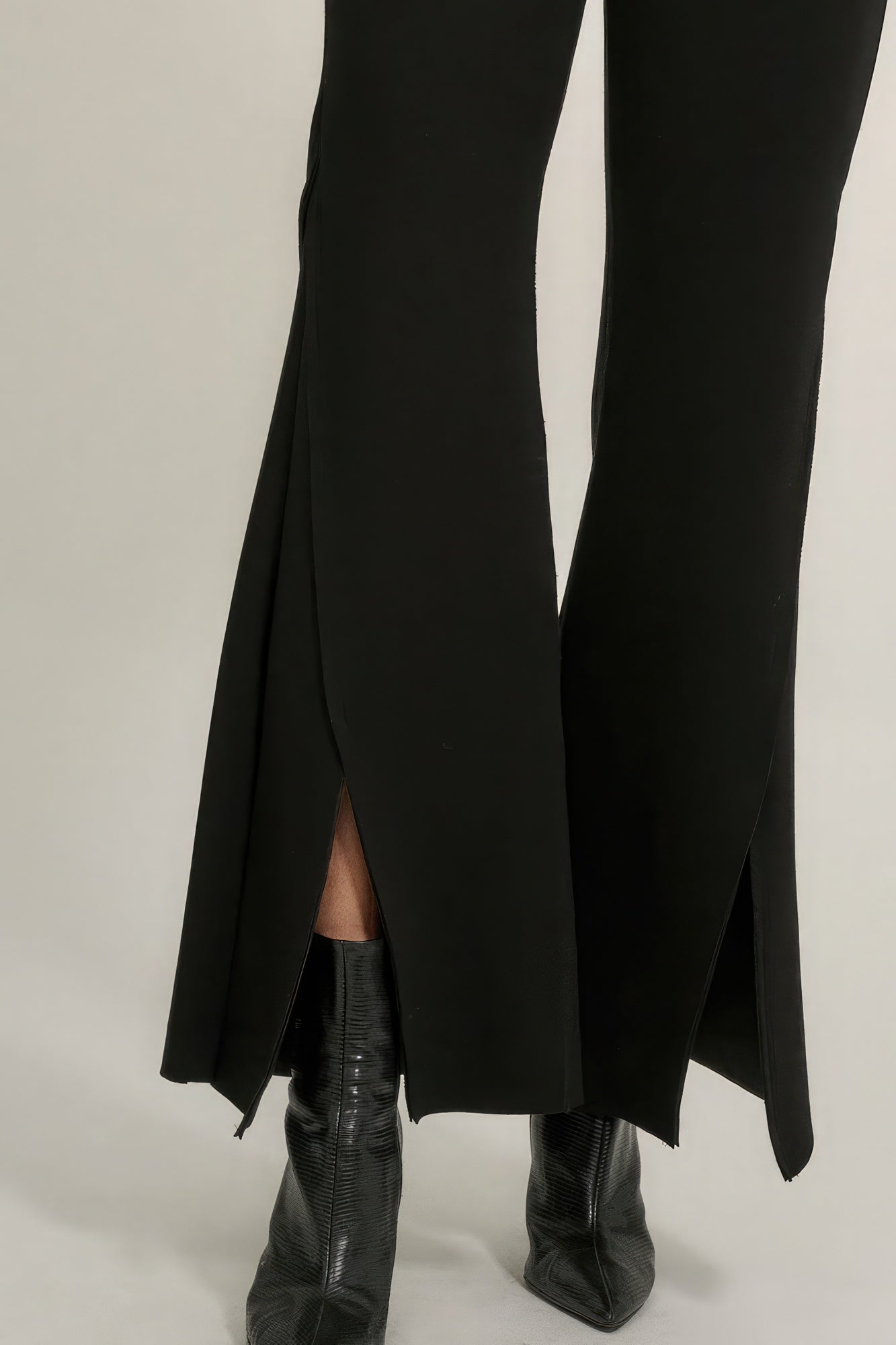 Black bell-bottom pants with long side slit and visible exposed seam
