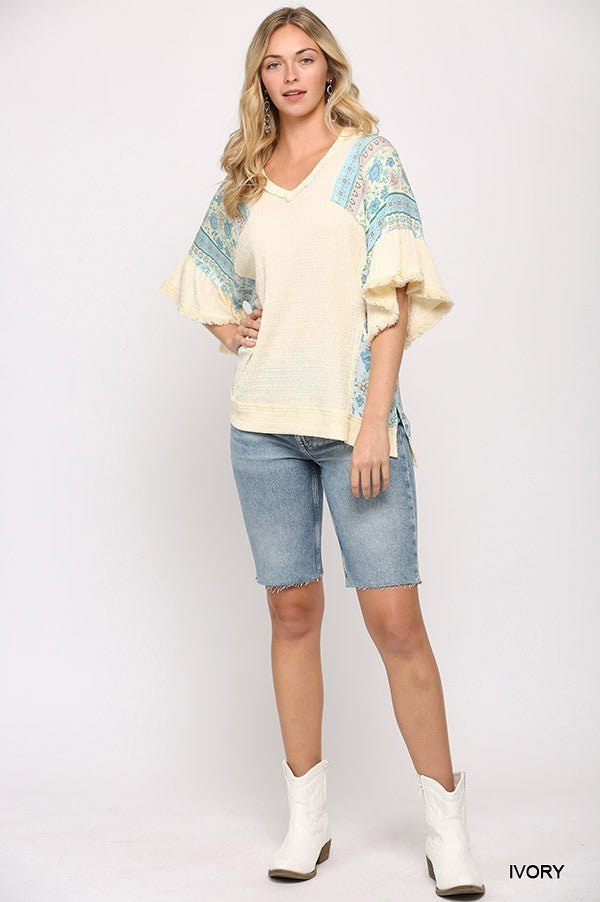 Ivory hi-low hem mixed texture top with patterned flutter sleeves and V-neck