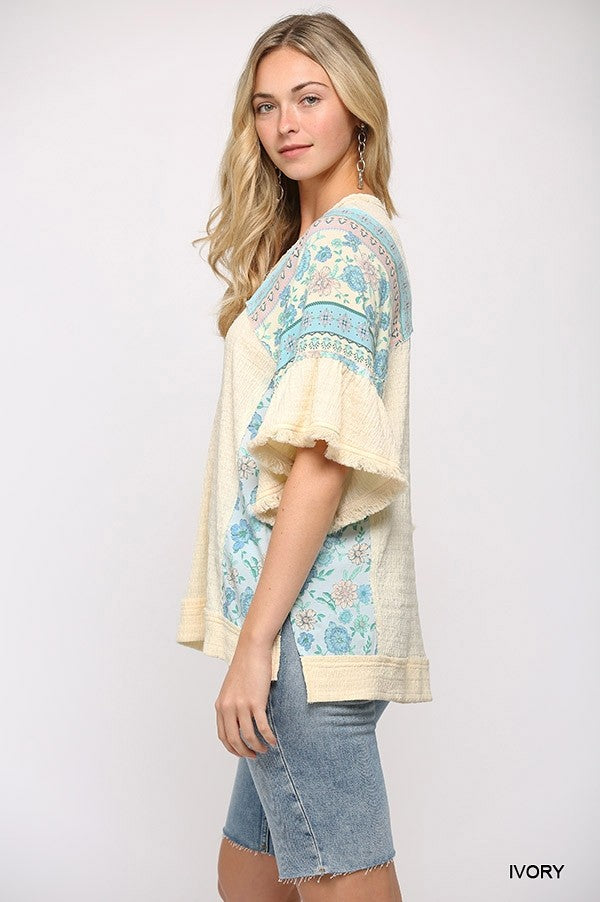 Ivory mixed knit top side view with printed sleeves and ruffled cuffs