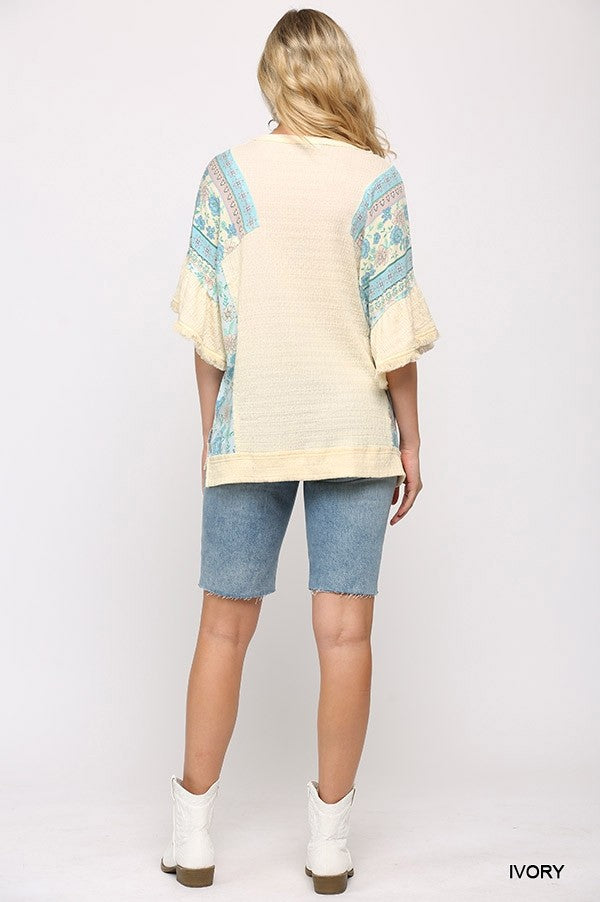 Ivory back view of knit top with patterned sleeves and hi-low hem